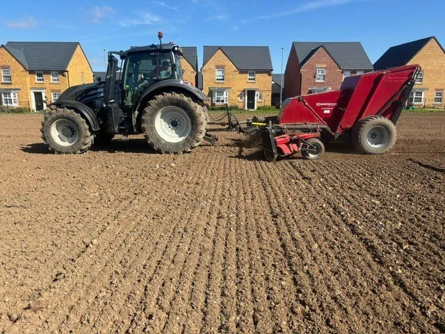 Valtra tractor with a stone burier working a housing site