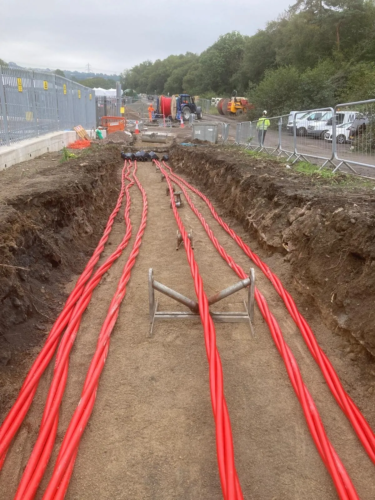 Red HV ducts laid in a trench ready for backfill