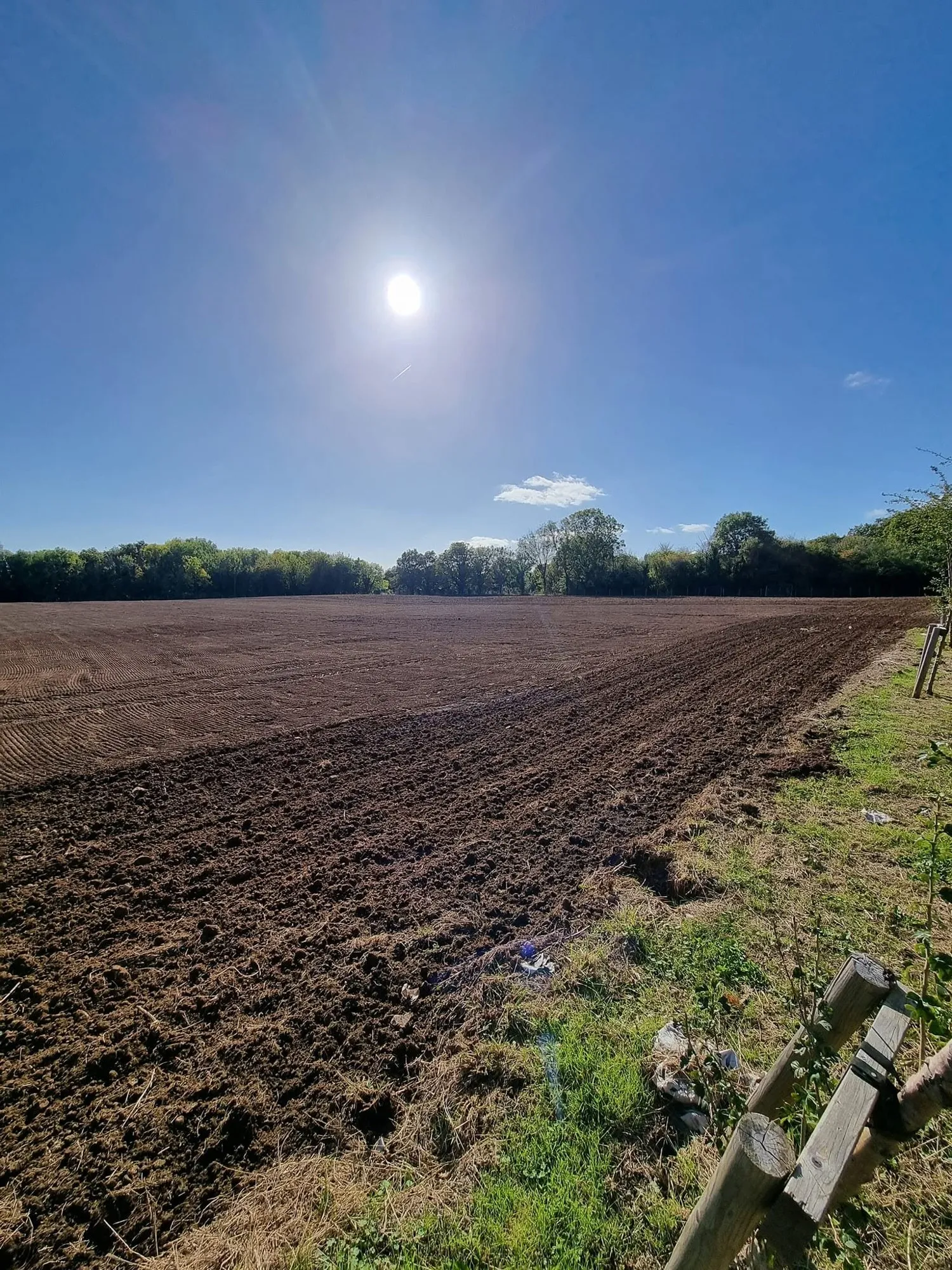 Freshly harrowed field under a clear sky
