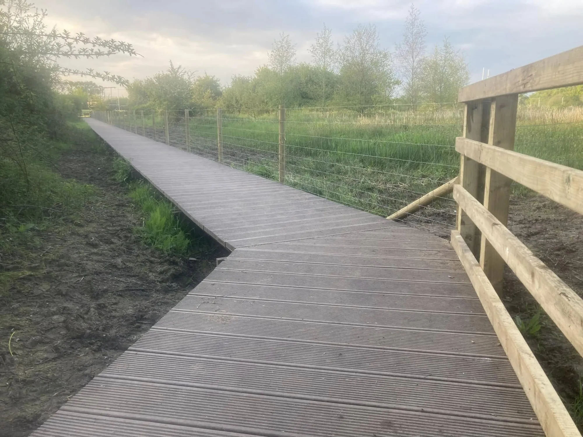 Boardwalk turning a corner across rough ground