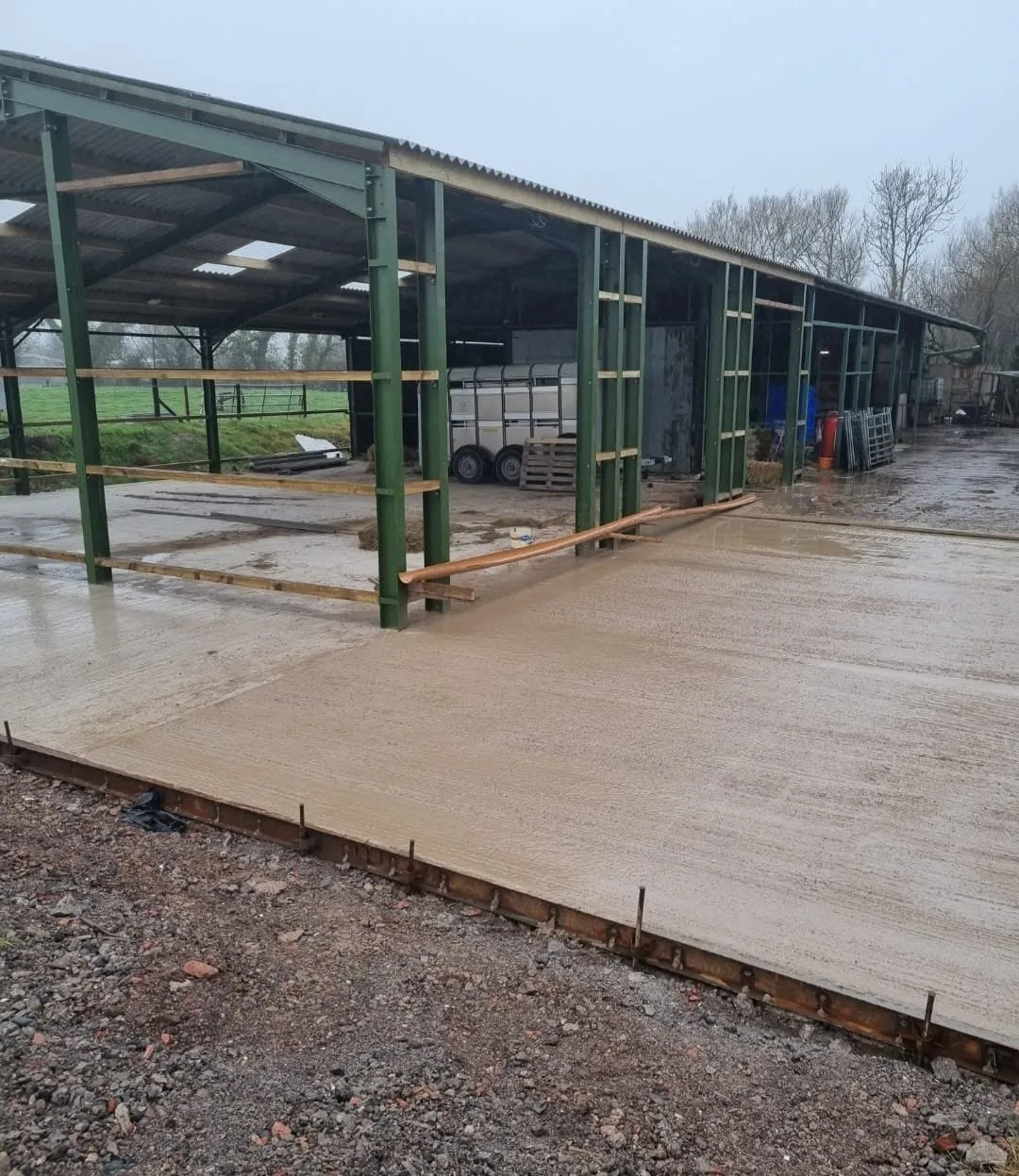 Concrete slab laid alongside a steel-framed barn
