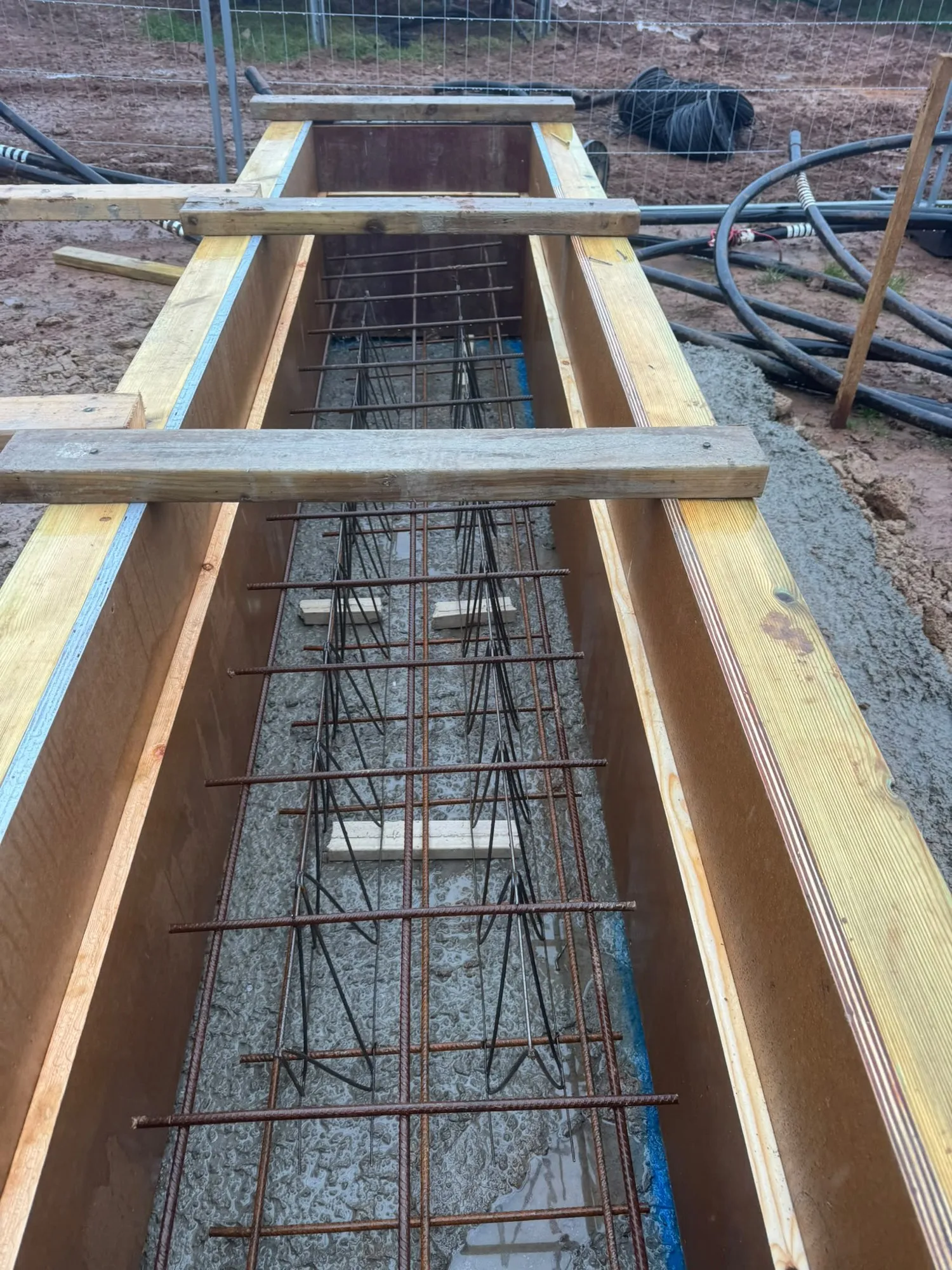 Reinforcement and formwork for a concrete base