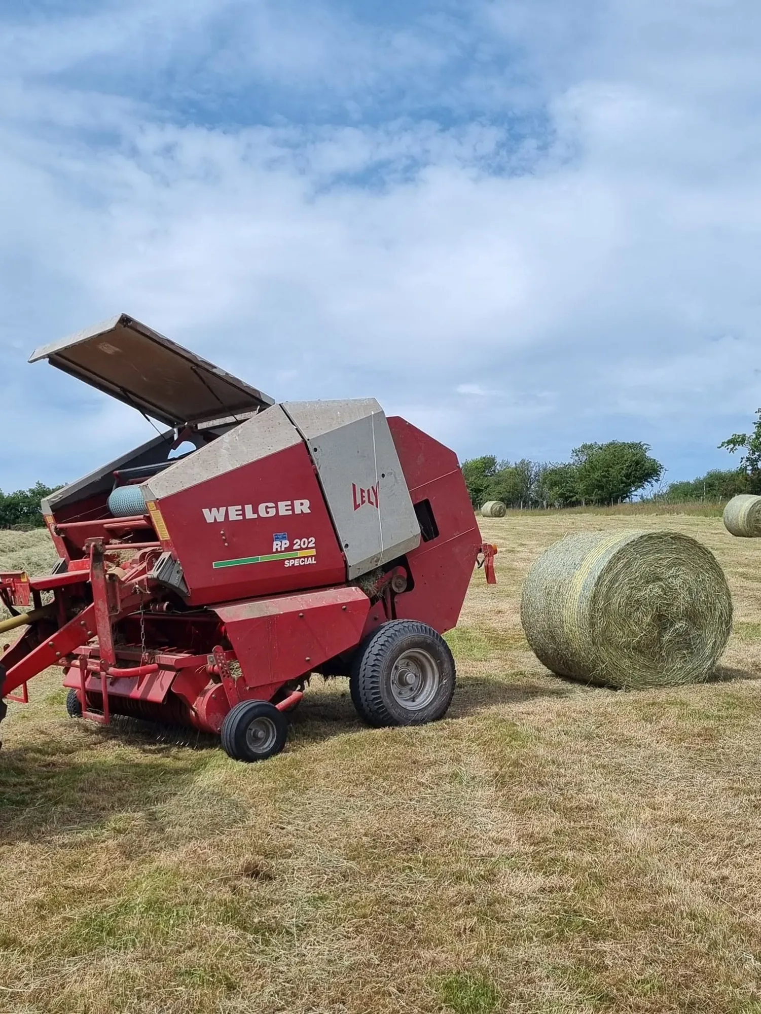 Round baler releasing a bale of hay