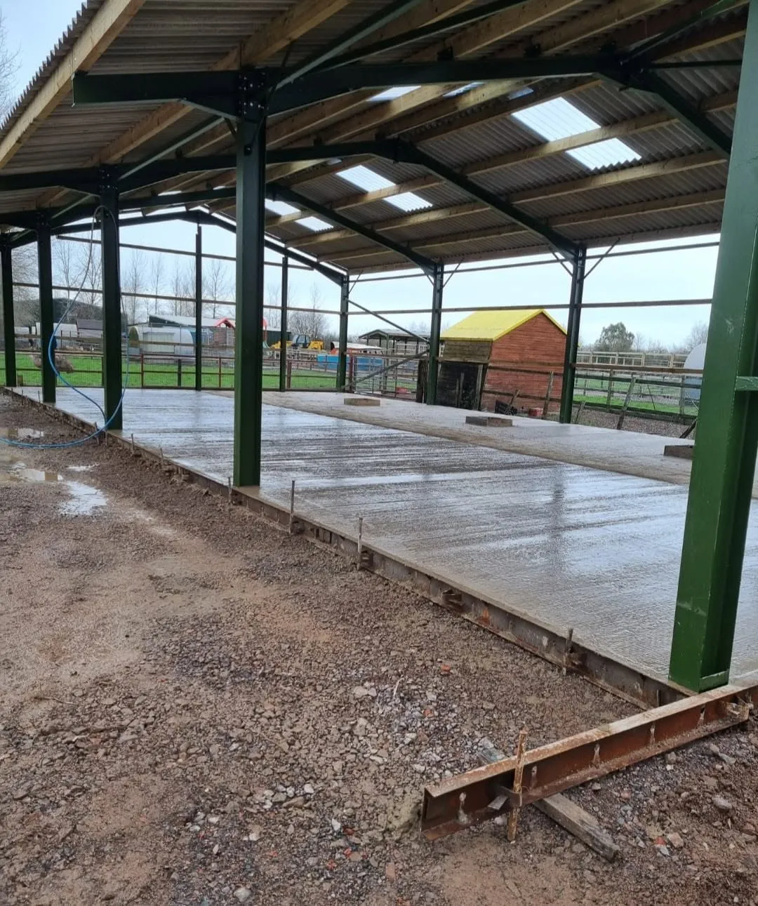 New concrete floor inside an open steel-framed building