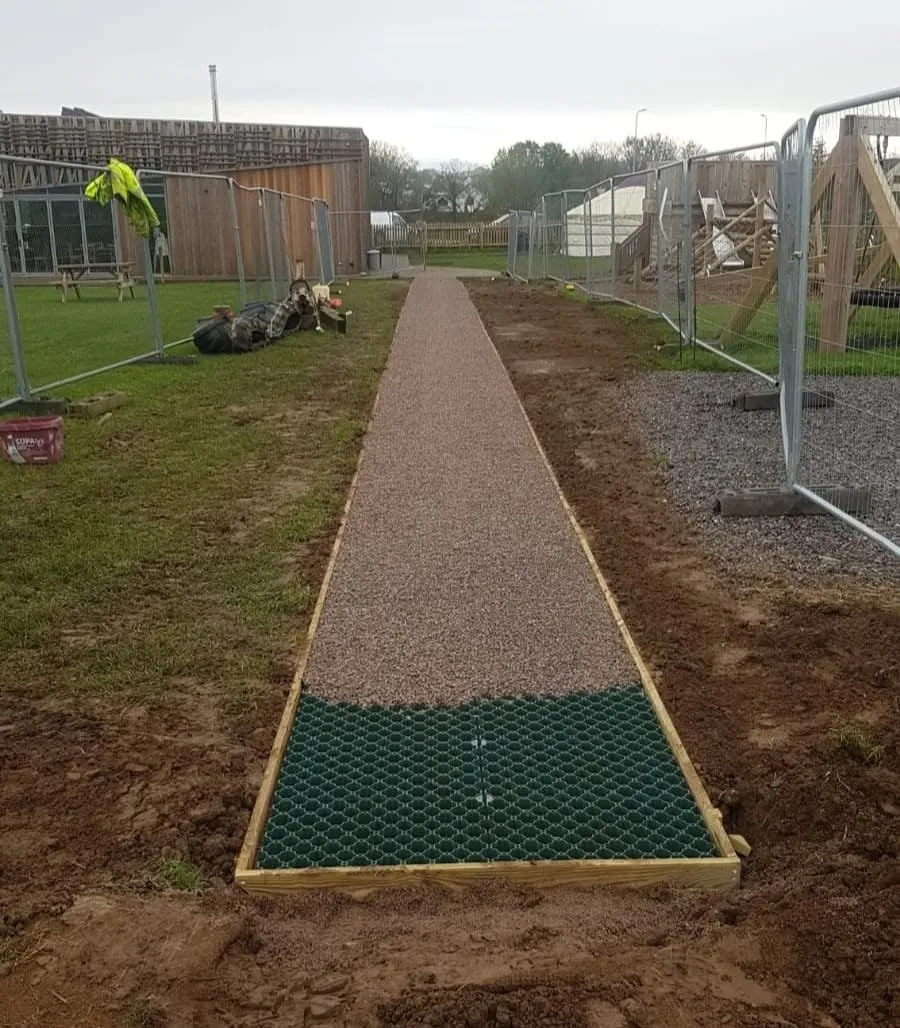 Gravel-filled footpath with reinforcement grid at the near end