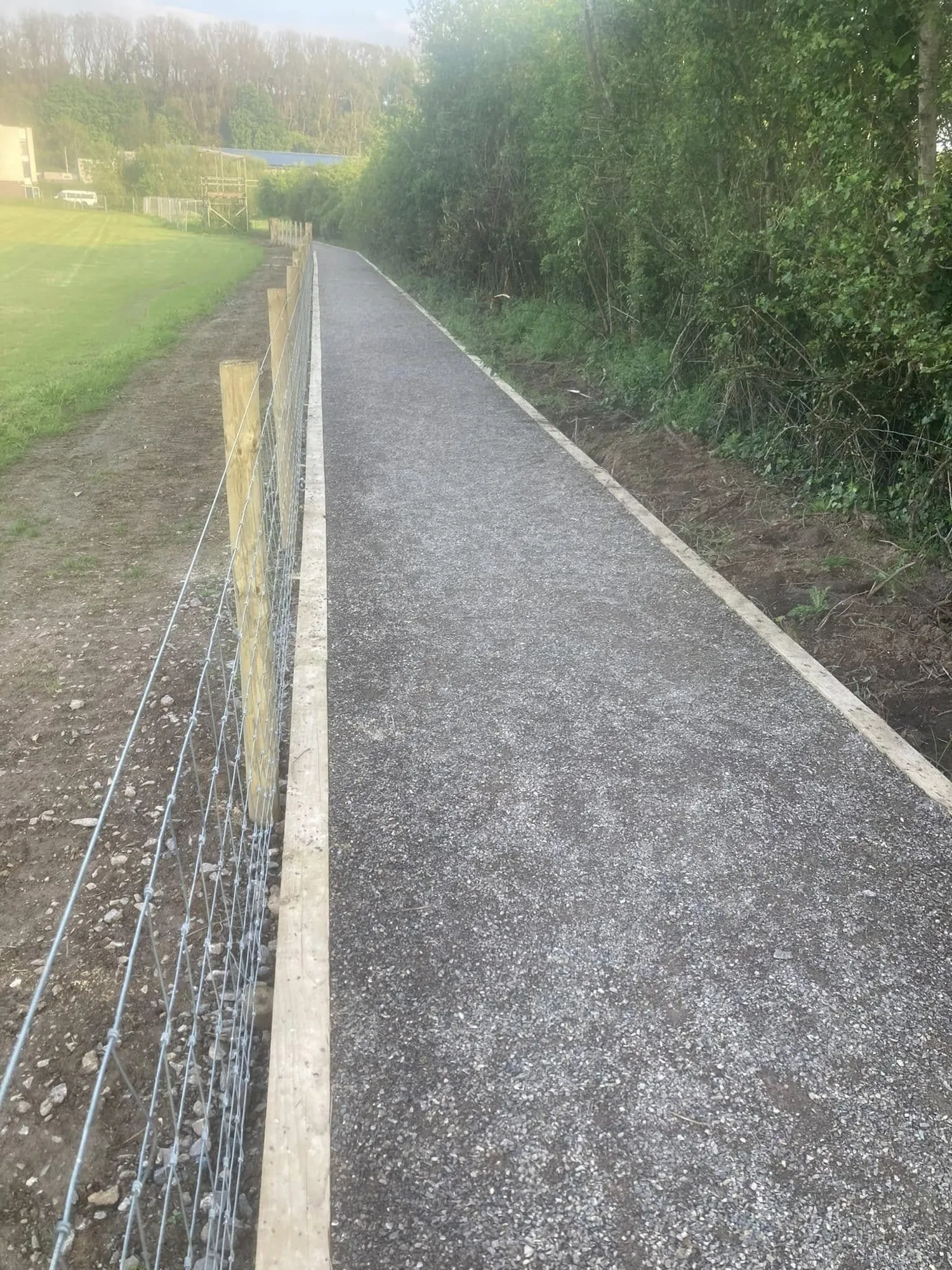 Stone footpath with timber edging beside a wire stock fence